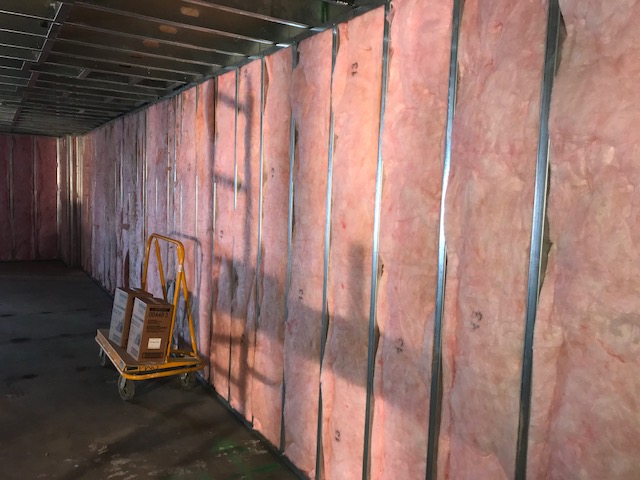 A wall under construction with pink insulation visible